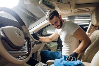 arabanın içinde oturan ve toz silerek sakallı yakışıklı adam