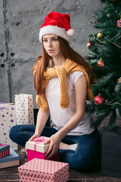 thoughtful girl with a gift sitting on the floor