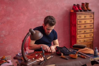 yakışıklı adam bez ayakkabıları için kesim üzerinde konsantre