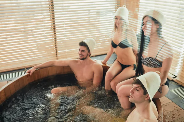 Grupo de amigos caucasianos diversos desfrutando jacuzzi no spa do hotel — Fotografia de Stock