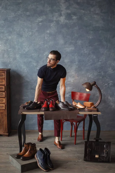 Awesome shoeshine man looking aside while standing at workplace — Stock Photo, Image