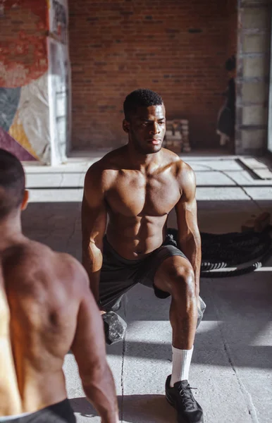 Dois atletas masculinos multirraciais que fazem lunges com peso no exercício indoor — Fotografia de Stock