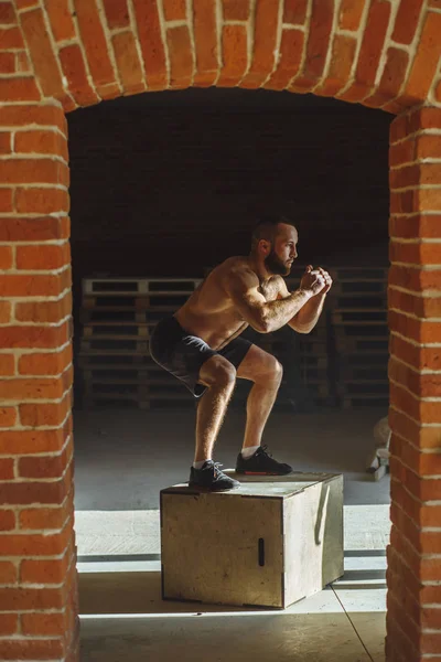 Kaukasiska atletisk man utför plyo box jump motion under crossfit träning — Stockfoto