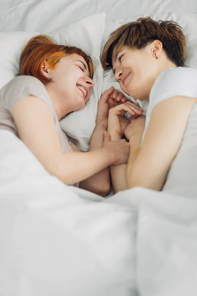 Aantrekkelijke meisjes een gesprek liggend op het bed — Stockfoto