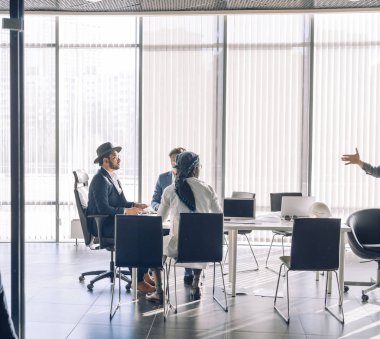 Çok kültürlü iş adamları modern panoramik pencerelere ofiste Toplantı