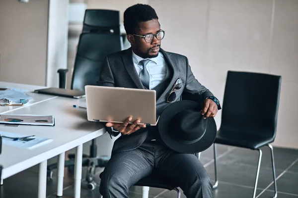Jovem pensativo elegante empresário afro-americano usando laptop — Fotografia de Stock