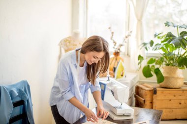 Güzel terzi stüdyosunda bir düğün elbise modeli ile çalışıyor
