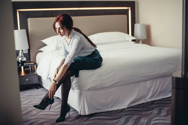 Senhora de negócios cansada depois de uma longa viagem descansando na cama no quarto de hotel . — Fotografia de Stock