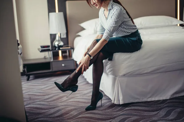 Senhora de negócios cansada depois de uma longa viagem descansando na cama no quarto de hotel . — Fotografia de Stock