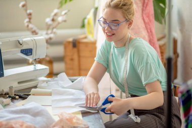 Güzel genç moda tasarımcısı kesme pembe dantel kumaş atölye odaklı