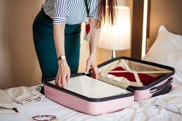 Mujer con ropa elegante empacando cosas en una bolsa de viaje, saliendo del hotel — Foto de Stock