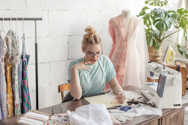 Mode-ontwerper op het werk. Talanted naaister het tekenen van de schets op haar werkruimte — Stockfoto