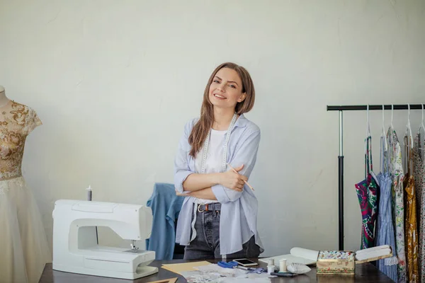 Close-up portrait of young seamstress or dressmaker a her workplace.