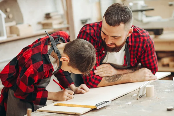 Dad and son in the workshop playing designing a model of a wooden plane — Stock Photo, Image