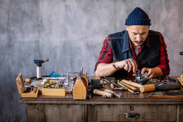 Молодий чоловік вчиться працювати з металом в ювелірному магазині — стокове фото