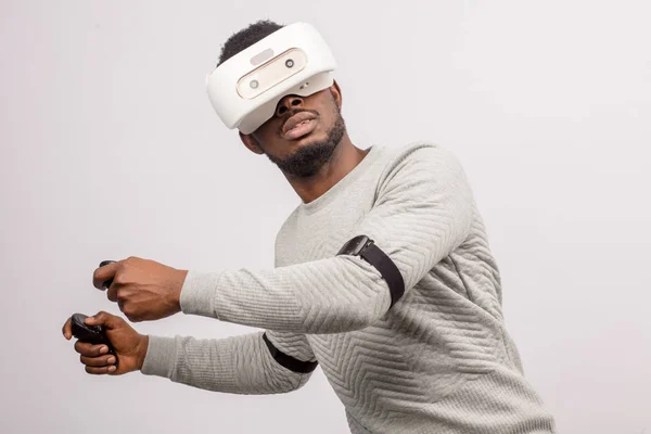 Young african man wearing virtual reality goggles isolated on white background