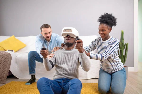 Multiracial group of friends having fun trying on 3D virtual reality goggles.