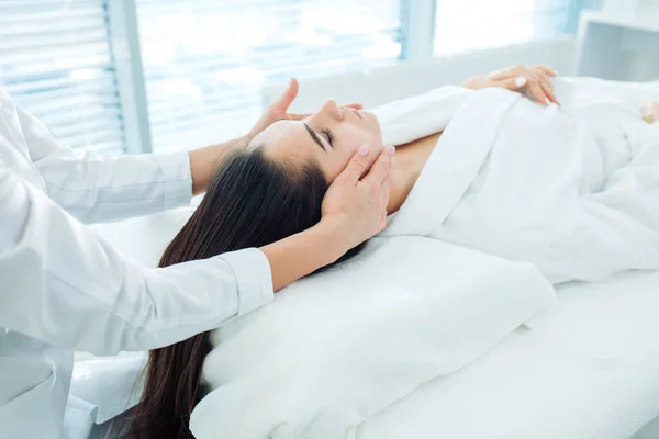 Mooi jong meisje met gezicht massage in spa salon — Stockfoto