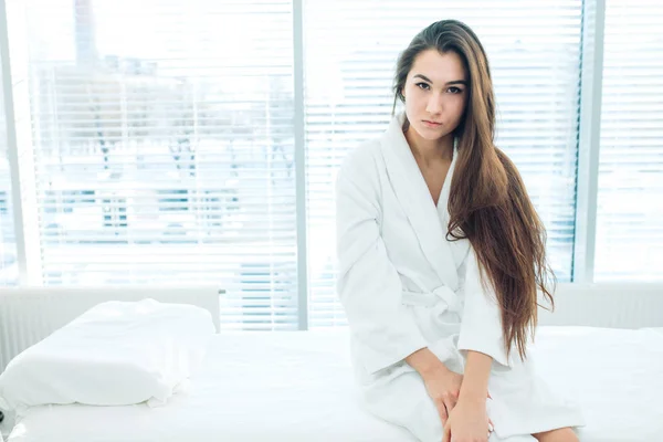 Jong brunette vrouw in wit badjas wachten voor LPG massage sessie — Stockfoto