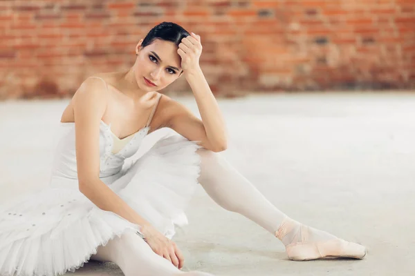 Pensativo dançarino incrível em elegante tutu branco olhando para a câmera — Fotografia de Stock