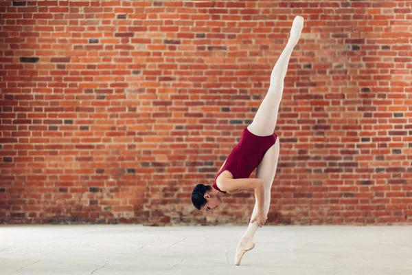 Atractivo gimnasta con traje de entrenamiento especial haciendo splits . —  Fotos de Stock