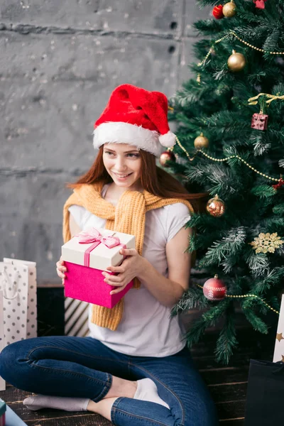 Favorit semester, tjejen kommer att lägga gåvan under trädet — Stockfoto