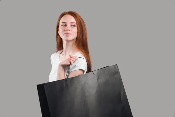 Chica pelirroja con bolsas de compras caminando —  Fotos de Stock