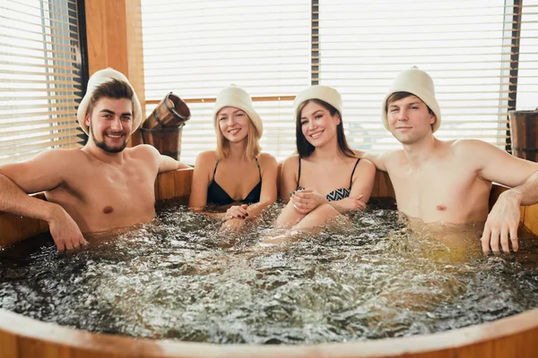 Grupo de amigos caucasianos diversos desfrutando jacuzzi no spa do hotel — Fotografia de Stock