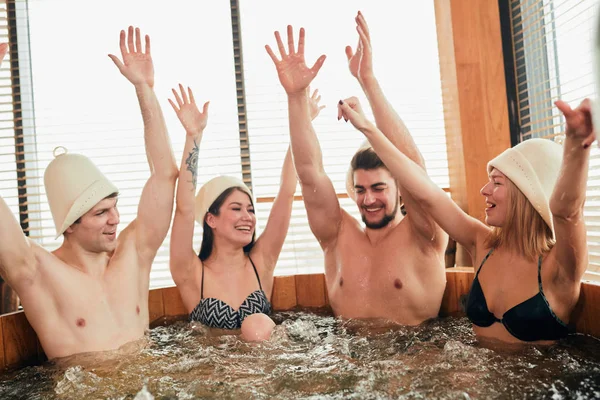 Grupo de amigos caucasianos diversos desfrutando jacuzzi no spa do hotel — Fotografia de Stock