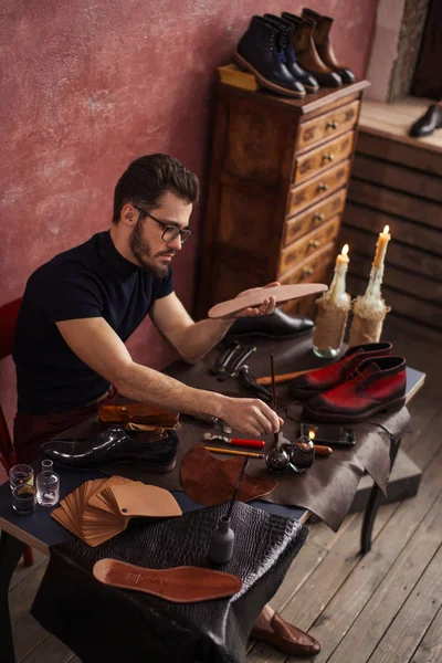 Hombre en gafas aplicando color en las suelas — Foto de Stock