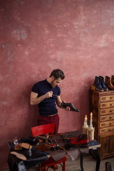 Joven zapatero comprobar la plantilla de calzado con estilo — Foto de Stock