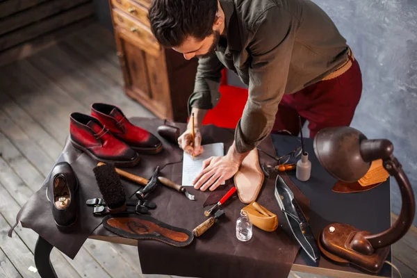 Cobber standing near the table and making up a paper pattern — Stock Photo, Image