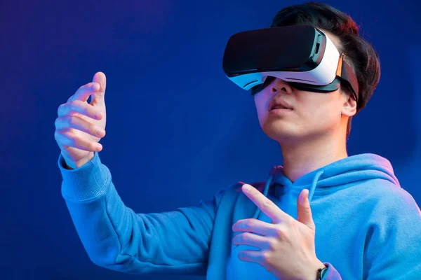 Chinese man met behulp van de virtual reality headset gebaren met de handen geïsoleerd — Stockfoto