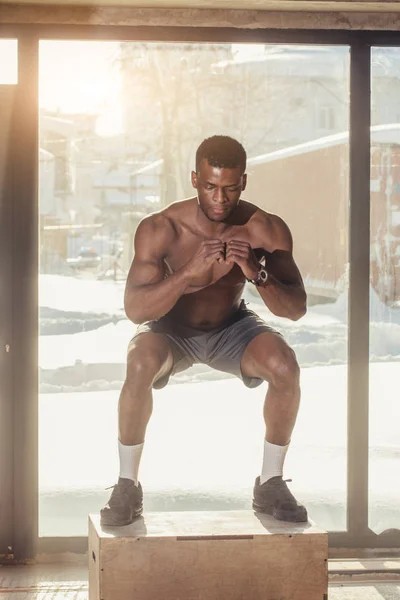 Afrikaanse sterke man uitvoeren plyo vak sprong oefening tijdens crossfit training — Stockfoto