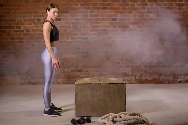 Vista lateral de la imagen de la mujer joven en forma haciendo un ejercicio de salto de caja . —  Fotos de Stock