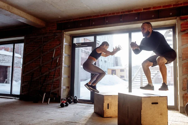 Mann und Frau springen in Turnhalle auf Boxen, Funcrional Workout für Menschen — Stockfoto