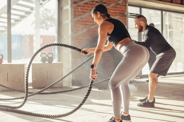 Donna e uomo in palestra allenamento funzionale con corda da battaglia esercizio — Foto Stock