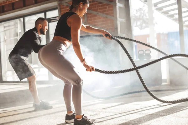 Donna e uomo in palestra allenamento funzionale con corda da battaglia esercizio — Foto Stock