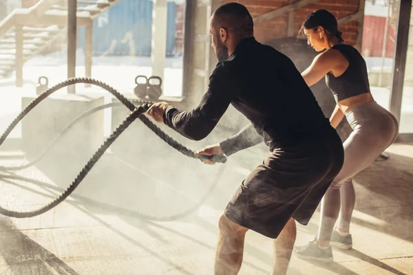 Žena a muž v tělocvičně funkční trénink s bitva lano cvičení — Stock fotografie