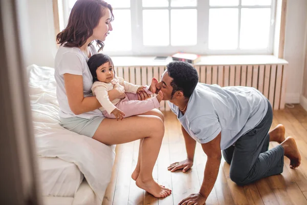 cheerful a mother hugging her son and father kissing his toes