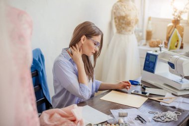 Moda Tasarımcısı iş başında. Talanted terzi onun çalışma alanı kroki çizim