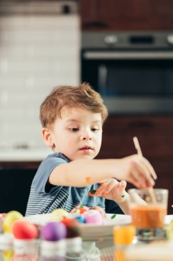 Mutlu küçük çocuk Paskalya yumurtaları, çocuklar ve yaratıcılık çiziyor.