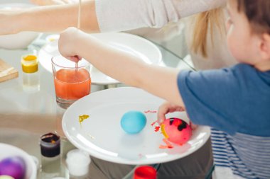 Mutlu Paskalyalar. Genç anne ve küçük oğlu Paskalya yumurtası boyuyor..