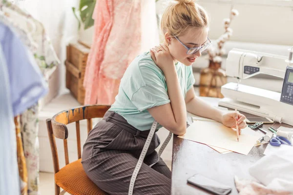 Mode-ontwerper op het werk. Talanted naaister het tekenen van de schets op haar werkruimte — Stockfoto