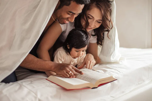 Attractive smiling couple getting pleasure from reading — Stock Photo, Image