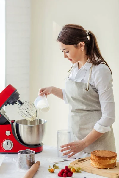 Attraktives Mädchen gießt Milch in die Sahne — Stockfoto