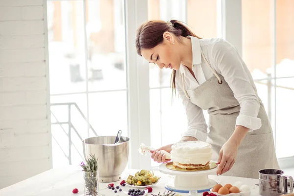 Ama de casa cubriendo pastel con crema. cerrar vista lateral foto . —  Fotos de Stock