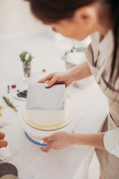 Γυναικείο χέρι κρατά ένα κόφτη pstry κατά την προετοιμασία του κέικ — Φωτογραφία Αρχείου