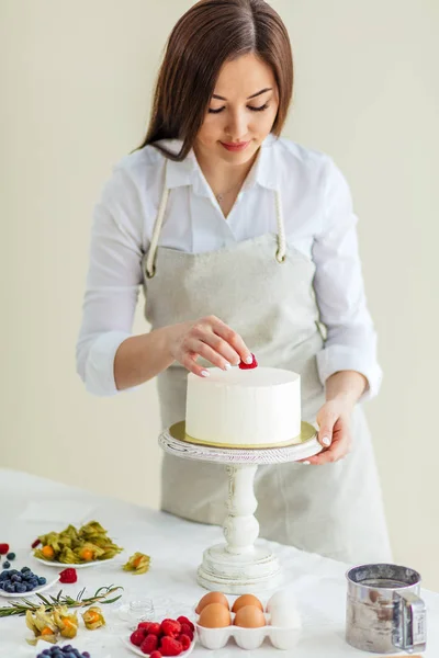 Kobieta kucharz przygotowuje słodkie ciasto z malinami — Zdjęcie stockowe