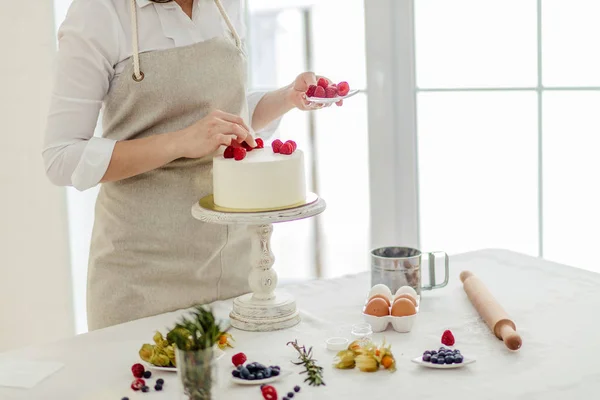 Niña usando bayas para la decoración pastel casero —  Fotos de Stock